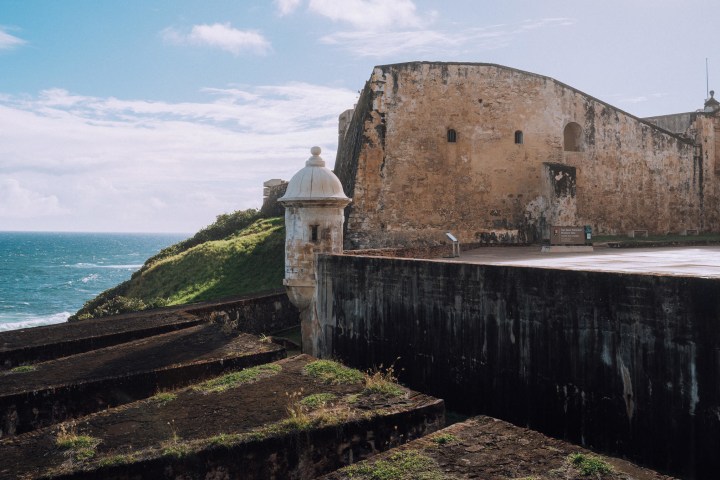 a stone castle next to a body of water