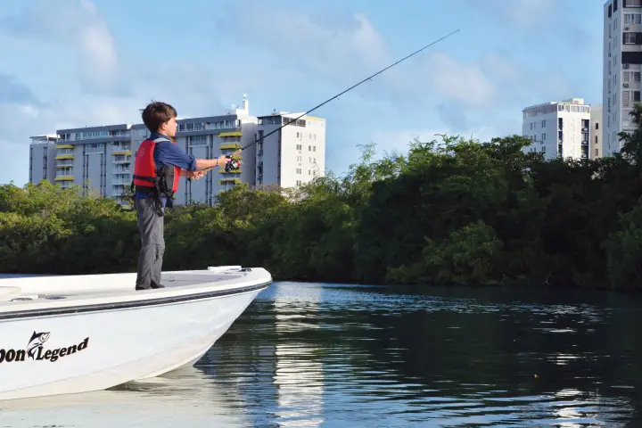 a man riding on the back of a boat in the water